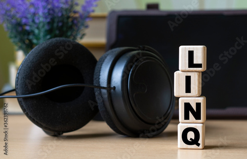 LINQ -word on cubes on the background of the tablet, headphones and a white cup photo