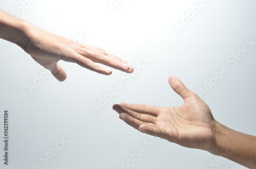 Two male hands reaching towards each other on isolated white background