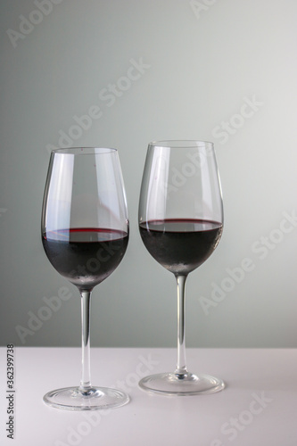 Two glasses of red wine in neutral background