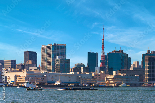 Barges towed by Tugboats sailing in front of the Shibaura Terminal on Tokyo port with the skyscrapers of Shiba district and the Tokyo Tower in the back. photo