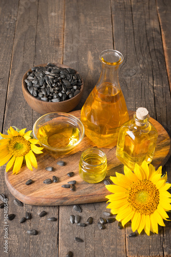 Sunflower oil and sunflower seeds on traditional rustic wooden background. 