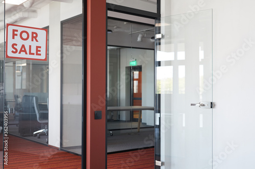 Graphic background image of empty office interior with red For sale sign on glass door, copy space