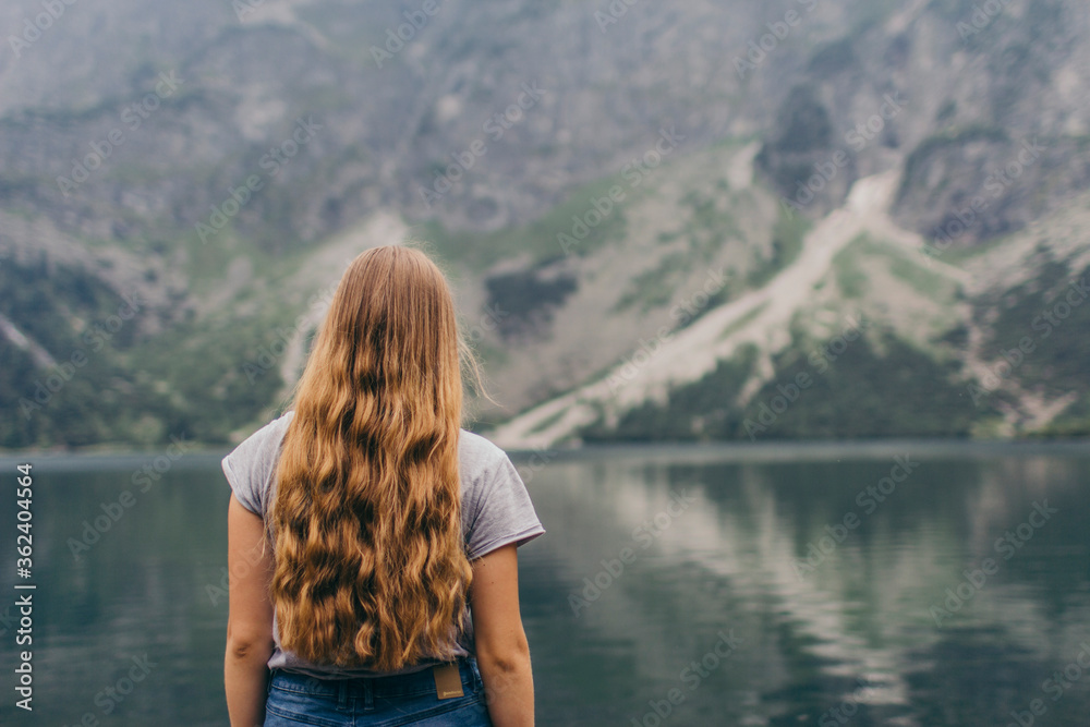 A person standing in front of a body of water