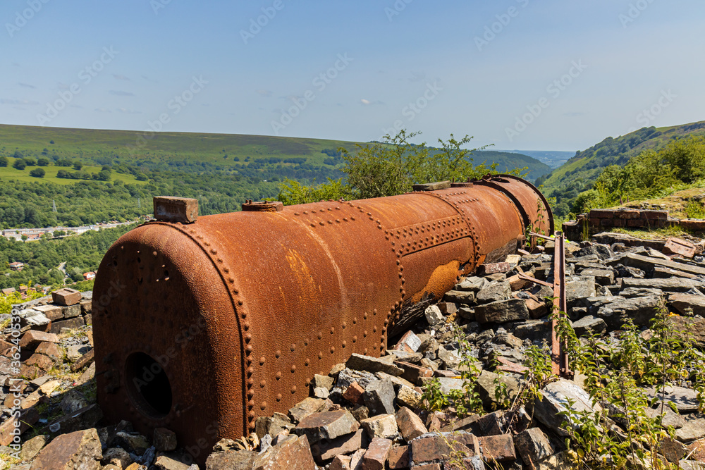 Rusting remains of an old, Victorian era boiler and lifting engine house abandoned on a hillside overlooking the Welsh town of Ebbw Vale