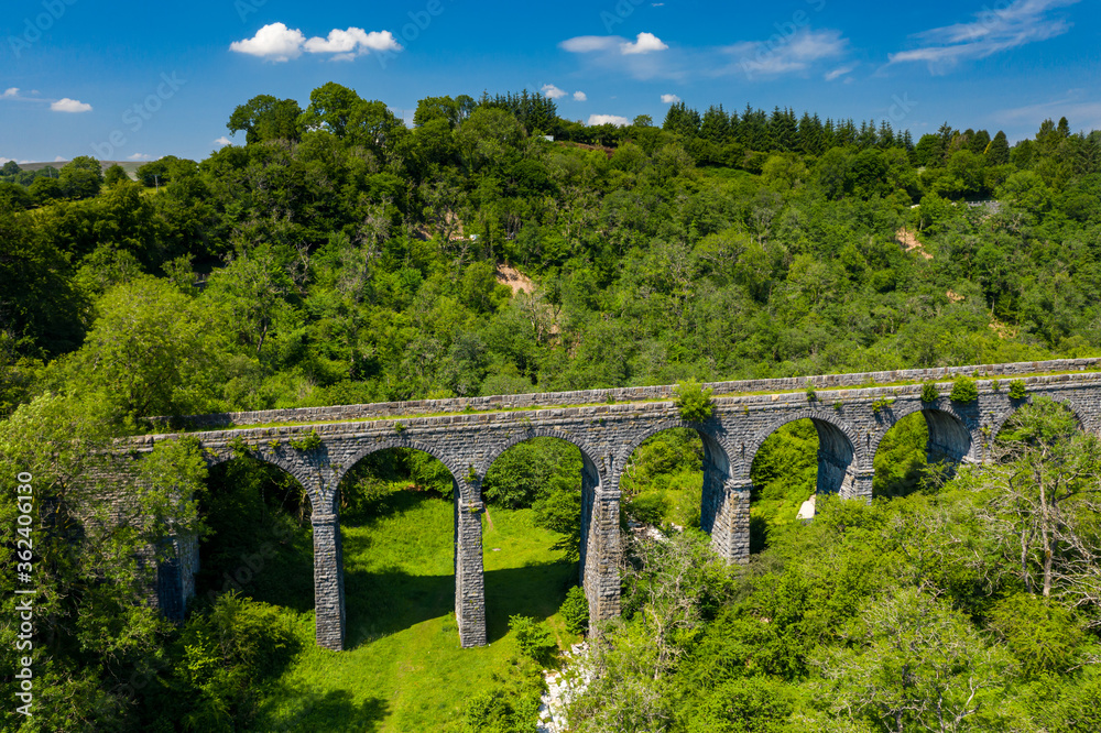 Aerial view of an old Victoria viaduct in a green valley on a beautiful summers day (Pontsarn Viaduct)