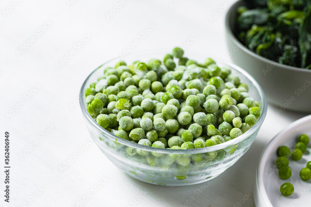 Frozen vegetables: green peas, spinach. Concept of healthy eating, easy cooking. White background copy space for text. Close up macro. Frozen vegetables: green peas, spinach. Concept of healthy eating, easy cooking. White background copy space for text. Close up macro.