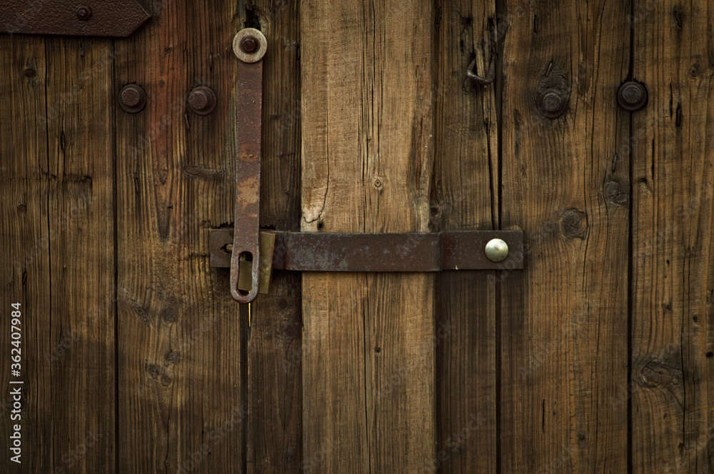 Stare drzwi z zamkiem, brązowe, drewniane.