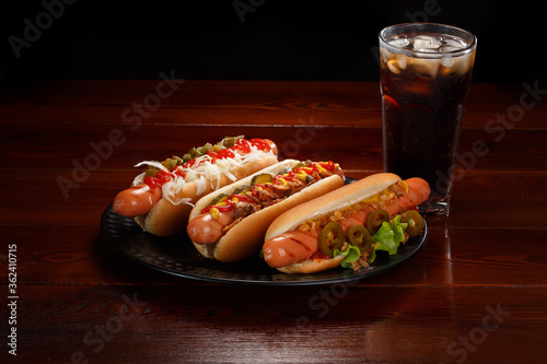 Set of various hot dogs and a glass of cola with ice.