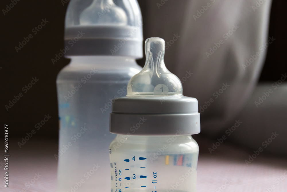 Feeding bottles with scale on dark background in kid's room Feeding bottles with scale on dark background in kid's room