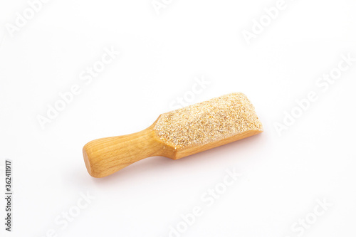 Scoop with ground grits on a white background