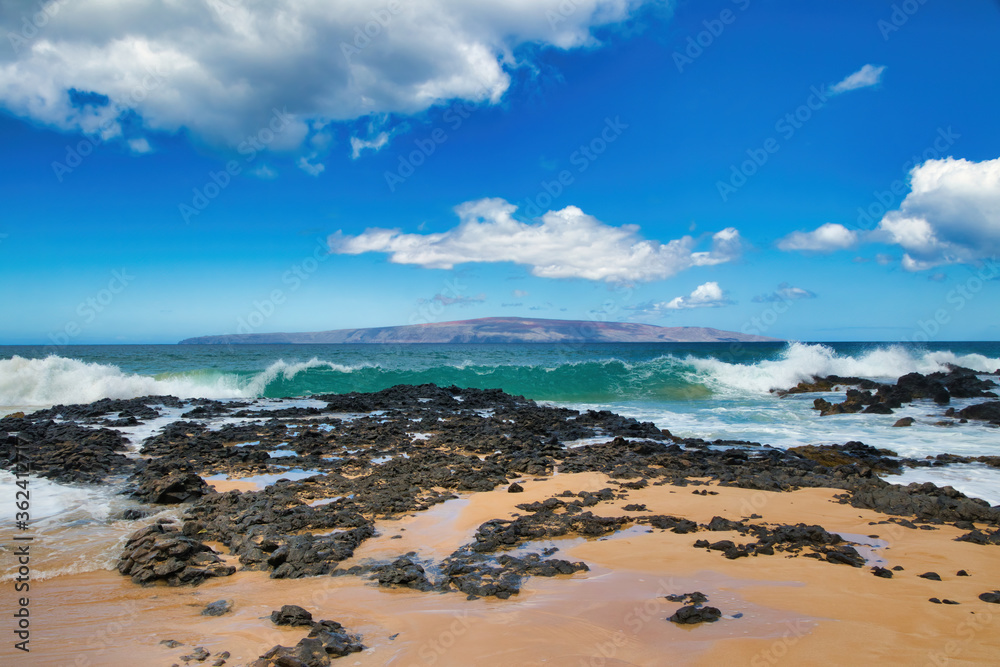 View of beach,ocean,surf and Kahoolawe in the distance from secret beach on Maui.