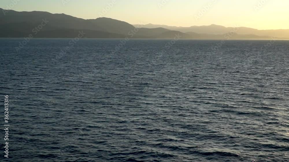 Traveling by water by the mountains in the sunset - slow motion Traveling by water by the mountains in the sunset - slow motion