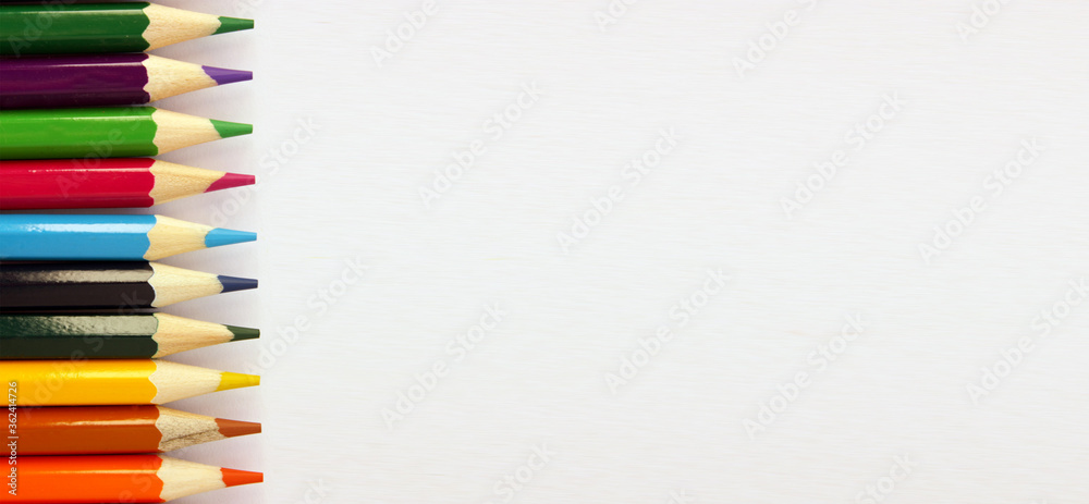 Colored pencils on white background. Lots of different colored pencils. Colored pencil. Pencils sharp. Pencils lie on the left. Beautiful background. Close-up. Copy space. Background. Flat lay. Banner Colored pencils on white background. Lots of different colored pencils. Colored pencil. Pencils sharp. Pencils lie on the left. Beautiful background. Close-up. Copy space. Background. Flat lay. Banner