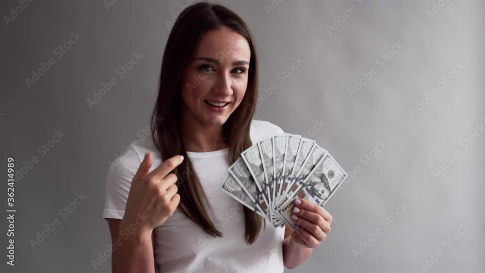millennial successful woman counting dollar bills money on neutral grey background millennial successful woman counting dollar bills money on neutral grey background
