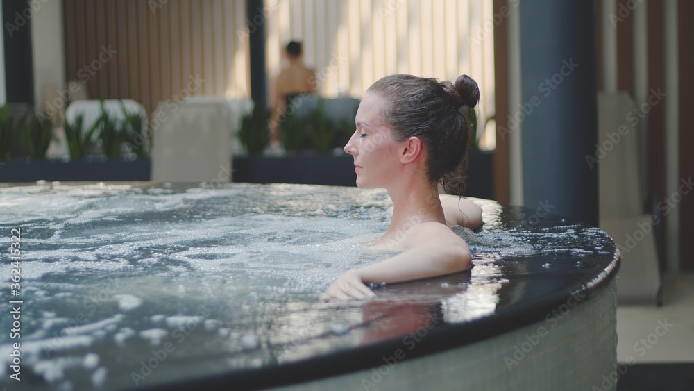 Woman relaxing in hot tube, Resting in whirlpool water in wellness spa resort. 