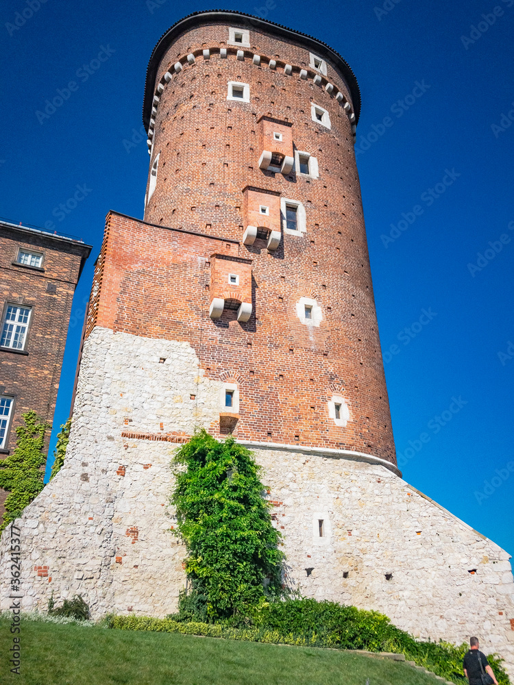 A large brick tower with a clock on the side of a building