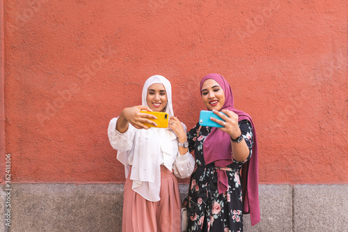 Beautiful Arab Girls Taking Selfie Outdoors. Lifestyle Concept. © MCStock