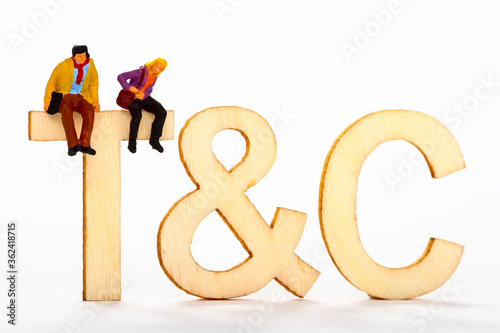 Terms and conditions abbreviated to t&c with a miniature figure couple sat on the letter T photo