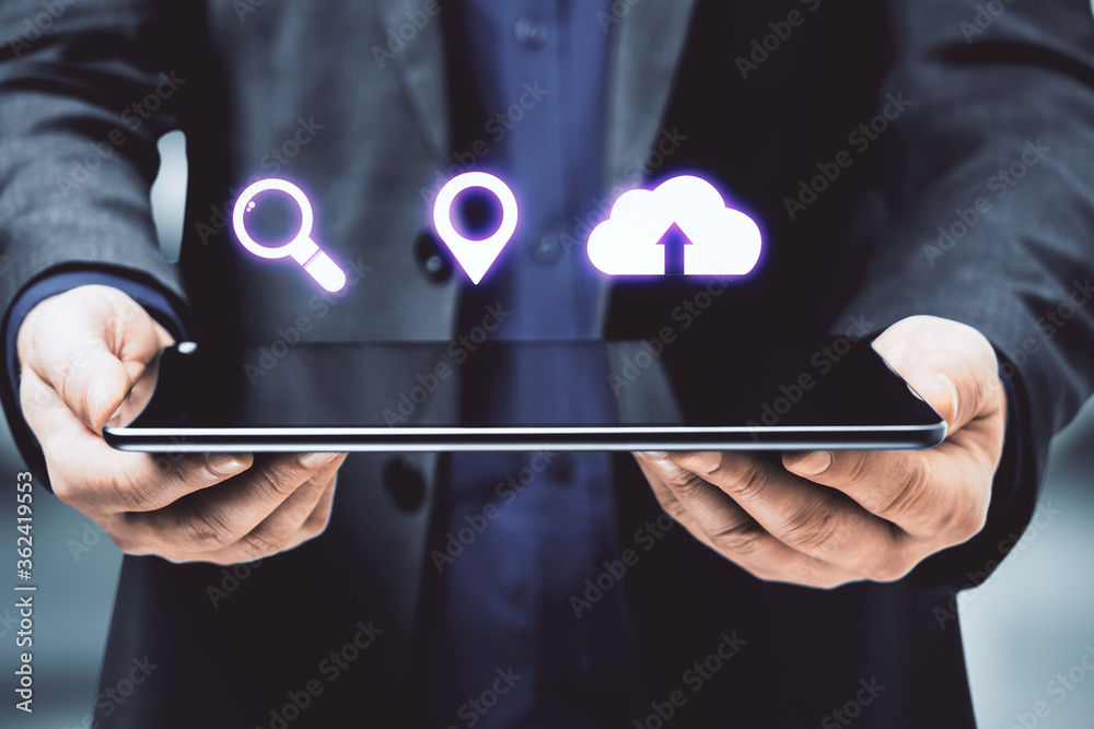 Businessman holding digital tablet with blank screen and digital icons.