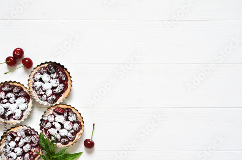 Tartlets with berries on a white wooden background. View from above.