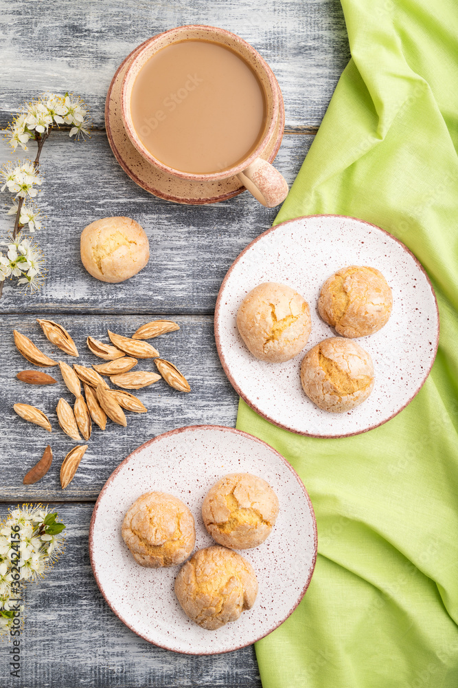 Almond cookies and a cup of coffee on a gray wooden background. Top view. Almond cookies and a cup of coffee on a gray wooden background. Top view.