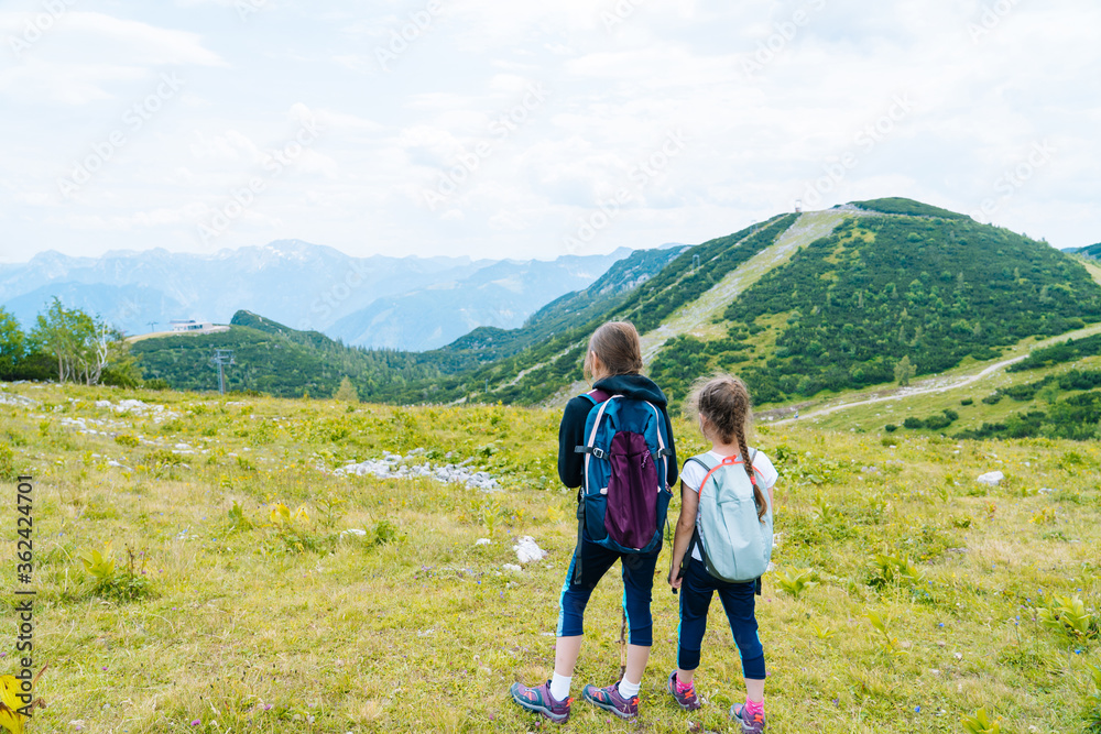Children hiking on beautiful summer day in alps mountains Austria resting on rock. Kids look at map mountain peaks in valley. Active family vacation leisure with kids. Outdoor fun and healthy activity Children hiking on beautiful summer day in alps mountains Austria resting on rock. Kids look at map mountain peaks in valley. Active family vacation leisure with kids. Outdoor fun and healthy activity