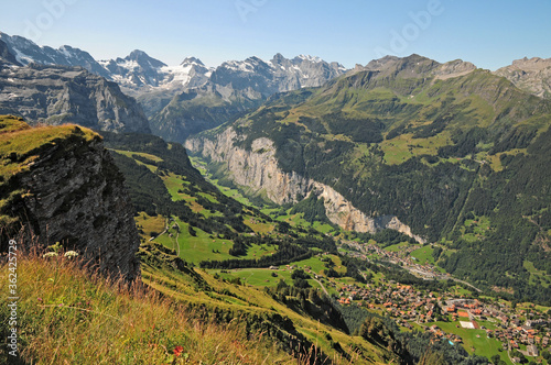 The town of Wengen dwarfed by the massive walls of the Lauterbrunnen valley. photo