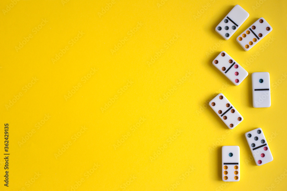 White dominoes on yellow background, top view. Board game. Place for text White dominoes on yellow background, top view. Board game. Place for text