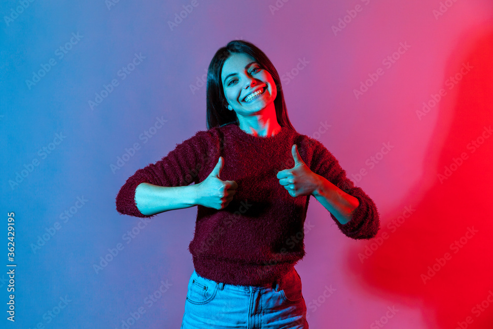 Well done, excellent job! Neon light portrait, joyful woman showing double thumbs up, gesturing like to camera and smiling broadly, expressing approval, positive feedback. indoor studio shot isolated Well done, excellent job! Neon light portrait, joyful woman showing double thumbs up, gesturing like to camera and smiling broadly, expressing approval, positive feedback. indoor studio shot isolated