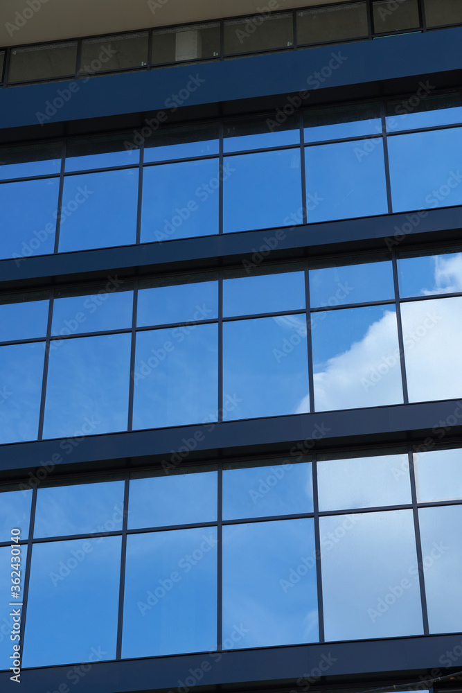 facade of a modern building on a bright Sunny day, blue sky and clouds reflecting in a glass, beautiful exterior of the new building facade of a modern building on a bright Sunny day, blue sky and clouds reflecting in a glass, beautiful exterior of the new building
