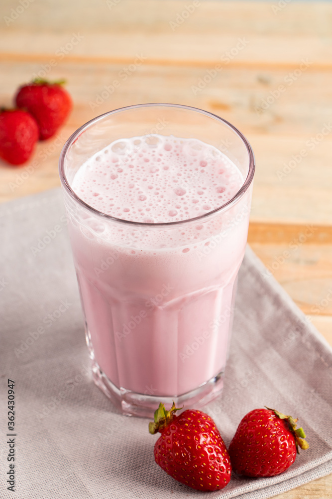 Milkshake with strawberries. Cold summer drink with berries on wooden background. Milkshake with strawberries. Cold summer drink with berries on wooden background.
