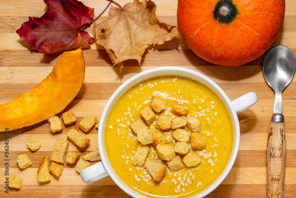 Autumn pumpkin soup with sesame seeds on a wooden background