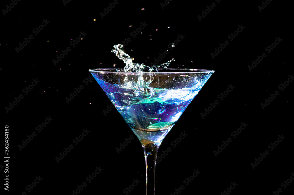Splash in martini glass, shot in studio on dark background