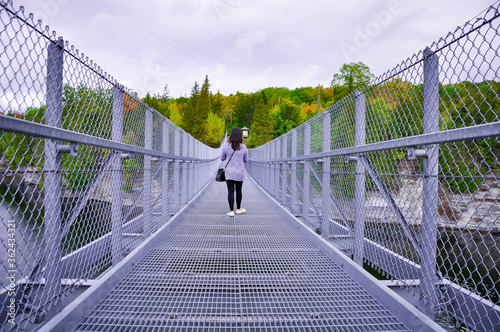 Girl walking alone in suspension bridge