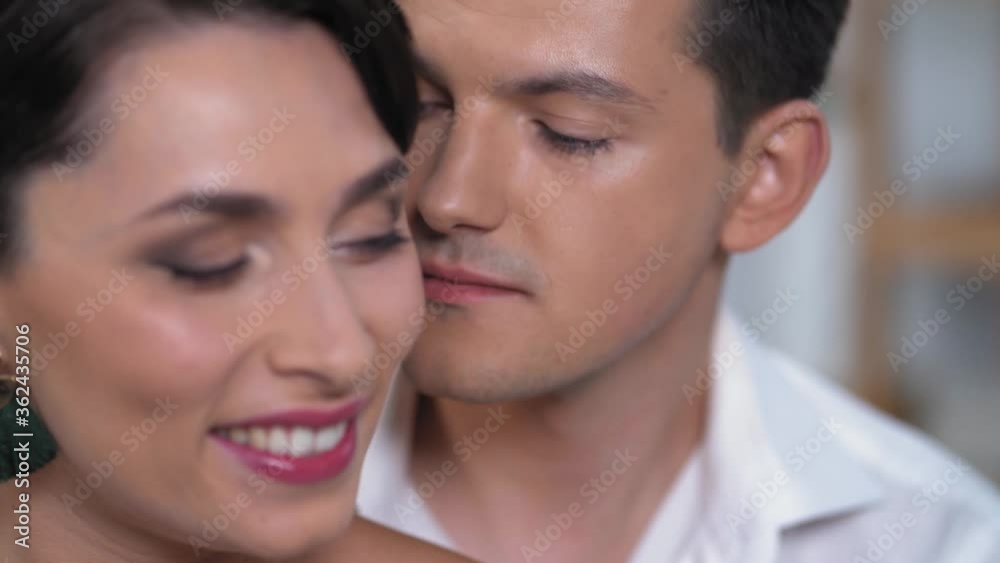The Beautiful Face Of The Young Woman. The Handsome Man Is Next To Her And Looks At The Female Passionately. Close-up Shot. The Beautiful Face Of The Young Woman. The Handsome Man Is Next To Her And Looks At The Female Passionately. Close-up Shot.