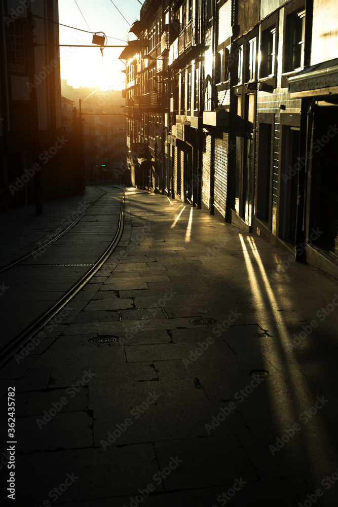 Narrow streets of the old city in the rays of a stunning dawn. Porto, Portugal.
