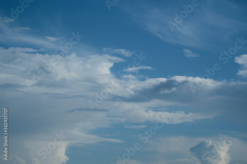 White cirrus clouds on a background of dark blue sky.
