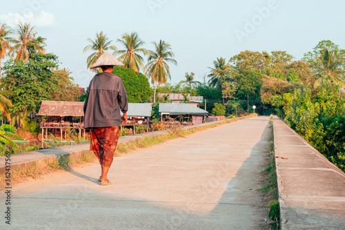 People walking on the historical bridge between Don Det and Don Khon. built by the French on the photo