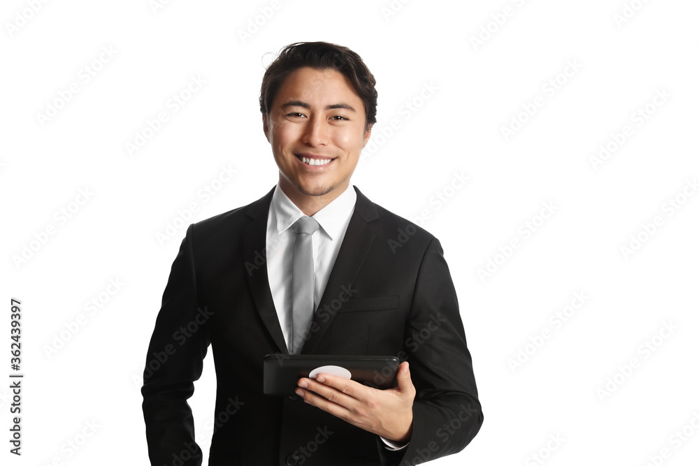 Fashionable and attractive young businessman holding a digital tablet reader, wearing
a black suit, grey tie and white collared shirt standing against a white background. Fashionable and attractive young businessman holding a digital tablet reader, wearing
a black suit, grey tie and white collared shirt standing against a white background.