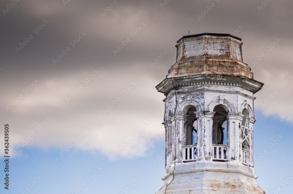 the abandoned steeple tower of a vintage colonial Massachusetts church under ominous cloudy skies with copy space