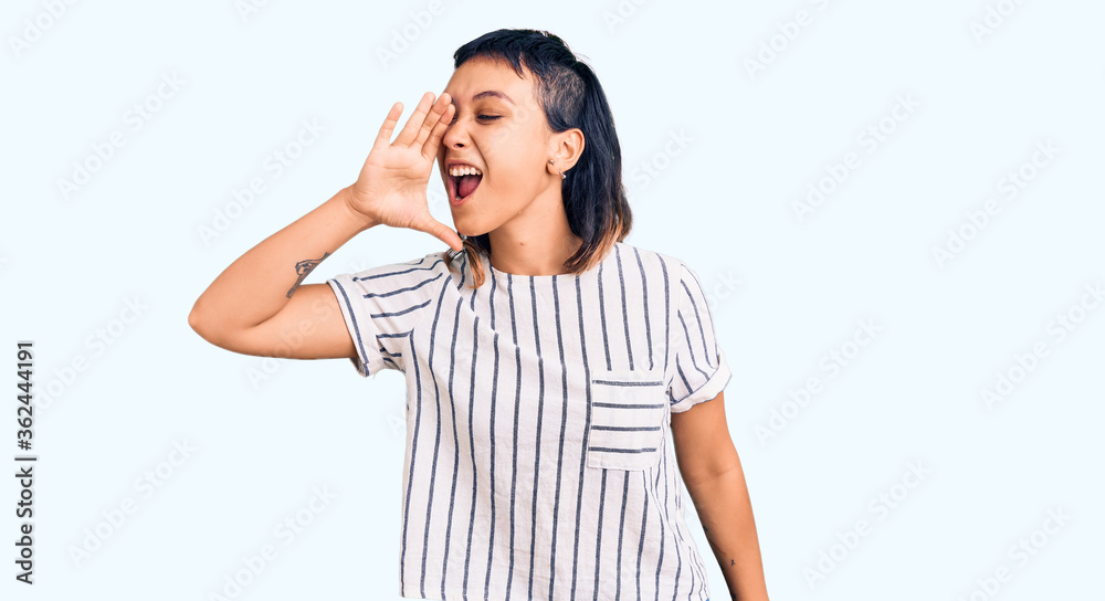 Young woman wearing casual clothes shouting and screaming loud to side with hand on mouth. communication concept. Young woman wearing casual clothes shouting and screaming loud to side with hand on mouth. communication concept.