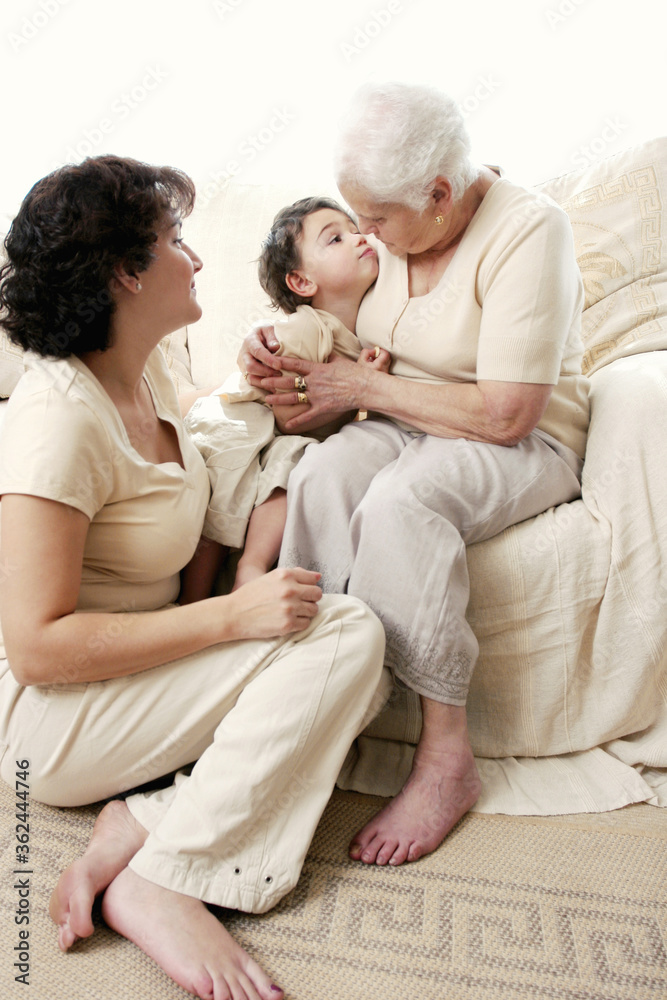 An old woman hugging her grandson while her daughter watching