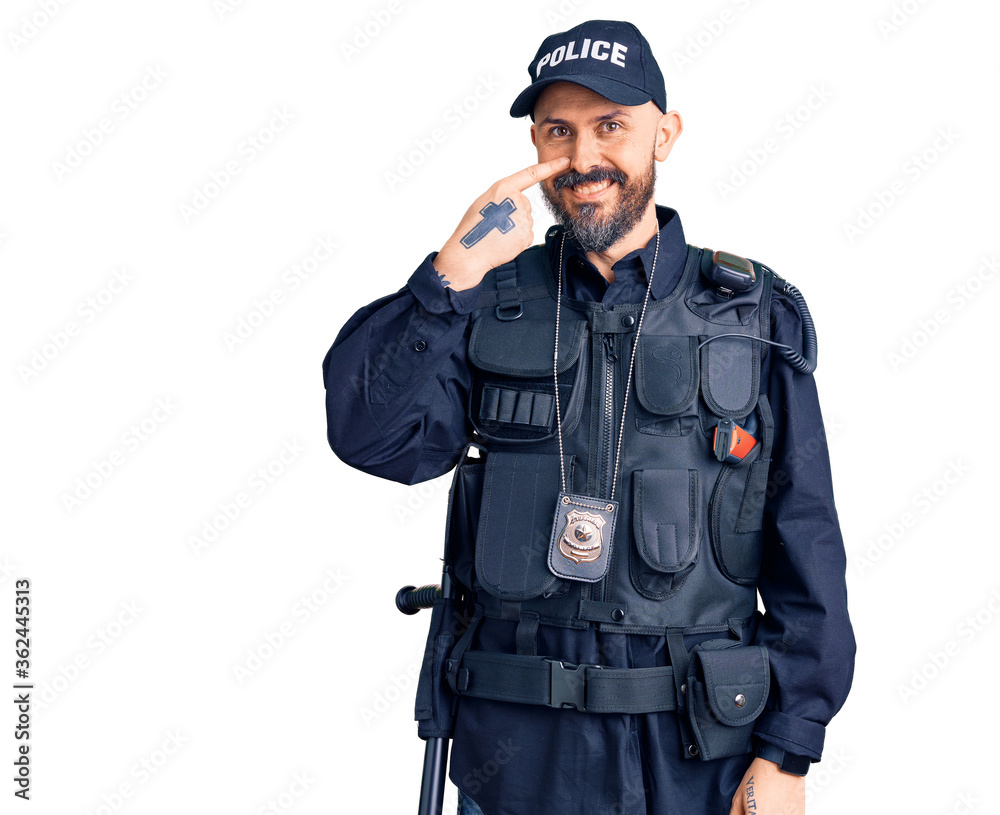 Young handsome man wearing police uniform pointing with hand finger to face and nose, smiling cheerful. beauty concept Young handsome man wearing police uniform pointing with hand finger to face and nose, smiling cheerful. beauty concept