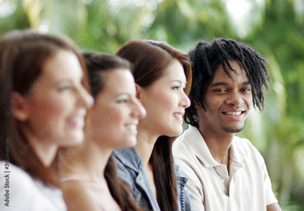 Three ladies and an African American man sitting in a row Three ladies and an African American man sitting in a row