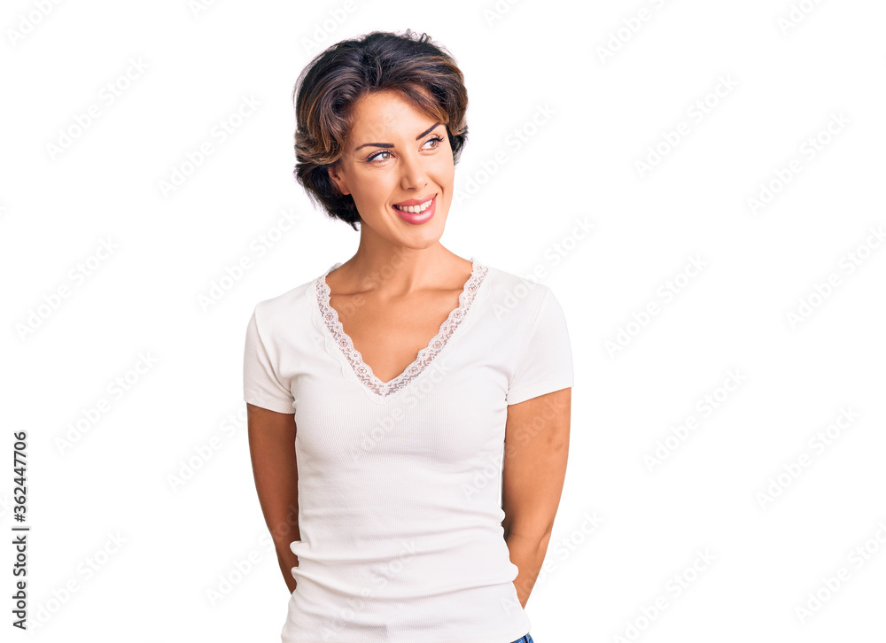 Young beautiful woman wearing casual clothes looking away to side with smile on face, natural expression. laughing confident. Young beautiful woman wearing casual clothes looking away to side with smile on face, natural expression. laughing confident.