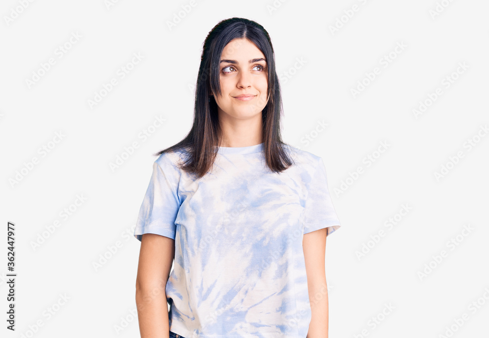 Young beautiful girl wearing casual t shirt smiling looking to the side and staring away thinking. Young beautiful girl wearing casual t shirt smiling looking to the side and staring away thinking.