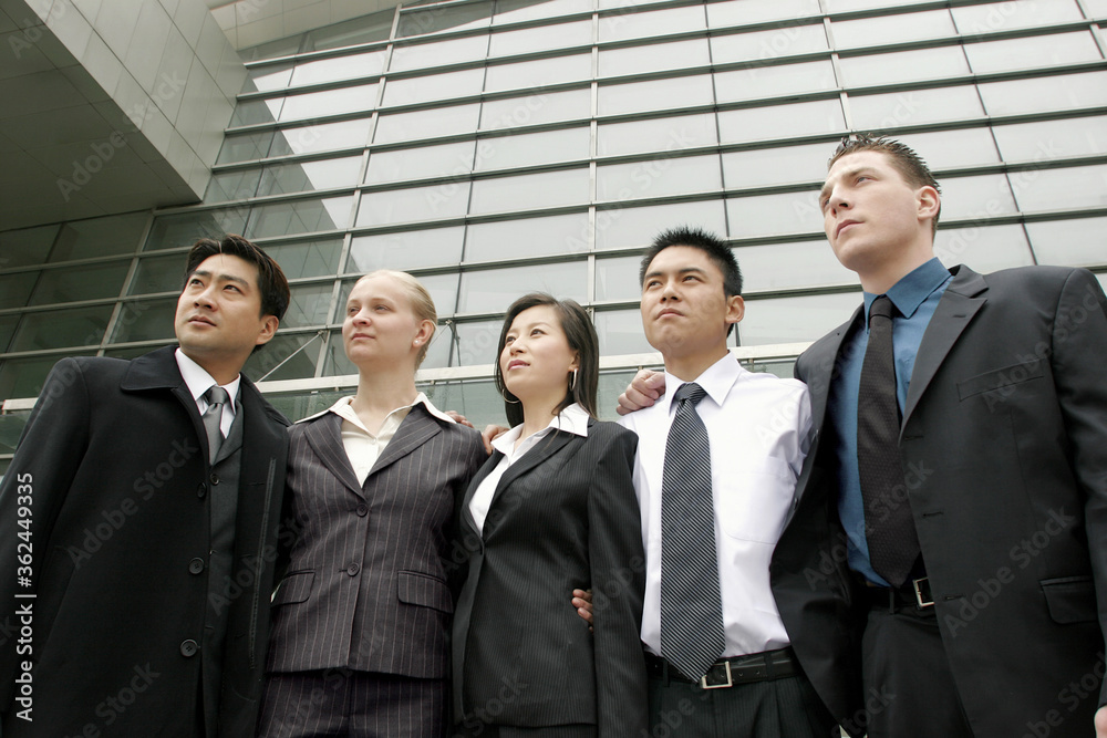 A group of corporate people standing in front of the office building A group of corporate people standing in front of the office building