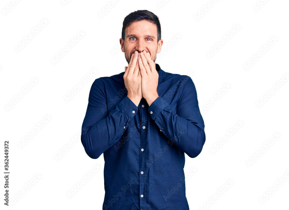 Young handsome man wearing casual shirt laughing and embarrassed giggle covering mouth with hands, gossip and scandal concept Young handsome man wearing casual shirt laughing and embarrassed giggle covering mouth with hands, gossip and scandal concept