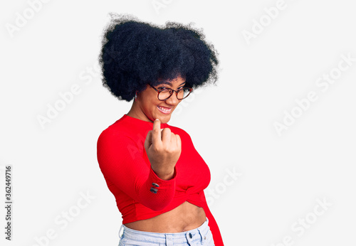 Young african american girl wearing casual clothes and glasses beckoning come here gesture with hand inviting welcoming happy and smiling