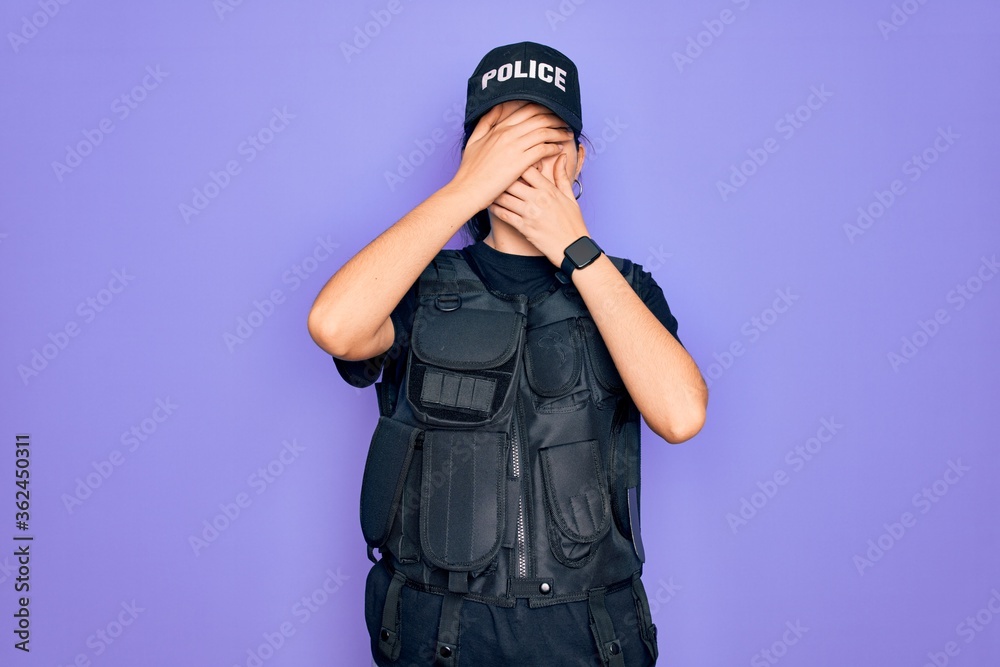 Φωτογραφία Young police woman wearing security bulletproof vest uniform over purple background Covering eyes and mouth with hands, surprised and shocked